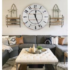 a living room filled with furniture and a large clock on the wall above the couch