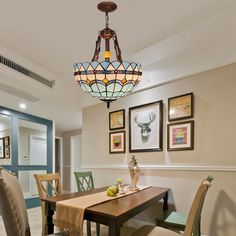 a dinning room table with chairs and a chandelier hanging from the ceiling