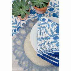 blue and white napkins on a plate with succulents