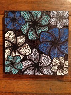 a wooden table topped with a blue and white flower design on it's surface