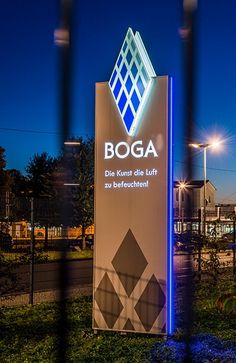 the entrance to boga is lit up at night with street lights in the background