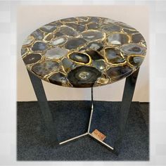 a table made out of oysters and metal legs on carpeted area with wall in background