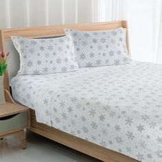 a bed with white and grey snowflakes on it