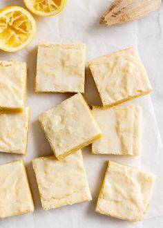 several squares of cake sitting next to sliced lemons