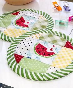 two watermelon placemats sitting on top of a table next to a bowl