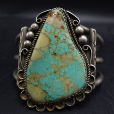 VINTAGE NAVAJO NUMBER 8 TURQUOISE STERLING SILVER CUFF BRACELET DESCRIPTION: A gorgeous specimen of Number Eight turquoise with quartz inclusions is the focal point of this exquisite cuff. This bracelet will be a cherished addition to your collection of fine vintage Southwestern and Native American jewelry. MEASUREMENTS: Interior of the cuff measures 5 5/8" with an additional 1 3/8" slightly adjustable gap. Total circumference: 7" Measures 2 1/2" straight across the widest part  (from wrist bone Classic Handmade Cuff Bracelet Collectible, Vintage Cuff Bracelet With Patina, Vintage Turquoise Bracelet With Inlay, Adjustable Turquoise Vintage Cuff Bracelet, Antique Patina Cuff Bracelet Collectible, Vintage Turquoise Multi-stone Jewelry, Southwestern Style Turquoise Hand-strung Jewelry, Bones Bracelet, Silver Numbers