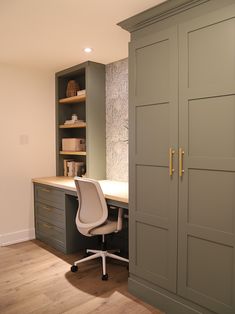 an office with gray cabinets and a white chair in front of the desk is shown