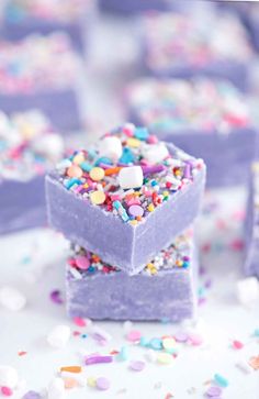 there are many small purple squares with sprinkles on them and one is filled with candy