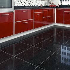 a kitchen with red cabinets and black countertops on the floor is shown in this image