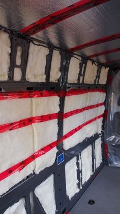 the inside of a vehicle with white fur and red tape on it's sides