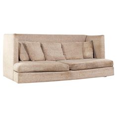 a beige couch with many pillows on it's back and side cushions in the middle