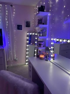 a bedroom with lights on the walls and a desk in front of a mirror that is lit up