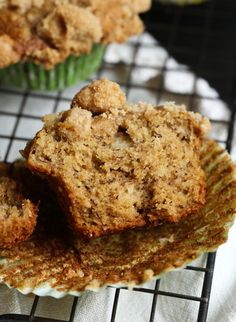 two muffins sitting on top of a cooling rack next to some other muffins