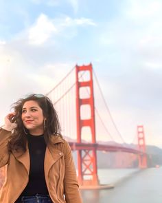 a woman standing in front of the golden gate bridge