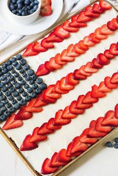 an american flag cake decorated with strawberries and blueberries