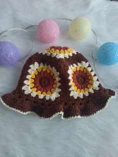 there is a crocheted hat with three balls around it