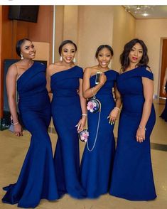 three women in blue dresses posing for the camera