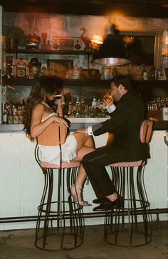 a man and woman sitting at a bar