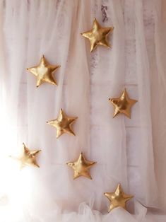 five gold stars are hanging on the curtain