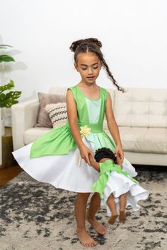 When you twirl in this enchanted green dress, it's as if you're caught in a joyful breeze, and the skirt flutters like the leaves in a magical forest. Designed for twirling - cut from a full circle of fabric which allows it to billow out as your little one spins and dances Gracefully tiered skirt, with three layers of flowing fabric that cascade elegantly Sunshine-hued flower embellishment at the waist for a finishing touch Made from breathable, stretchy, mid-grade soft knit fabrics Accessories Child Dress, Flowing Fabric, Knit Fabrics, Fabric Accessories, Twirl Dress, Magical Forest, Full Circle, Plush Animals, Tiered Skirt