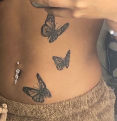 a woman's stomach with three butterflies on the side and one butterfly attached to her belly