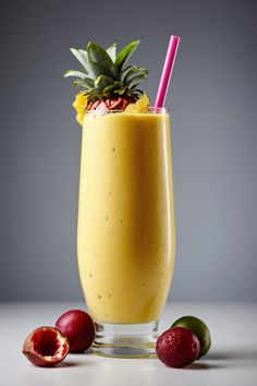 a smoothie is garnished with a pineapple on top and surrounded by fruit