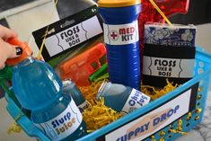 a blue basket filled with lots of different types of toys and water bottles next to each other