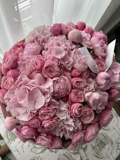 a bouquet of pink flowers sitting on top of a table