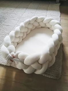 a large white round object sitting on top of a wooden floor next to a rug