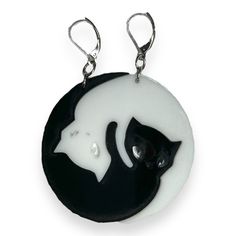 If necklaces aren't really your thing, try these Officially Licensed Emily the Strange® Yin Yang Cat Mismatched XL Ear Hooks on for size. The pieces really do fit together on this pair of mismatched yin-yang cat earrings. This set makes a really great gift for your eccentric cat friend that's also into quirky cat jewelry. This pair contains nickel free, surgical steel hooks on solid black and white acrylic charms. Sold as a pair, one black and one white kitty earring Nickel free, surgical steel Emily Strange, Cat Design Earrings With Cat Ears, Black Cat Ears Jewelry With Cat Design, Black Novelty Jewelry With Cat Design, Black Cat Design Drop Earrings, Emily The Strange, Black Cat Jewelry Pendant Necklace, Cat Jewelry, Acrylic Charms