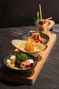 three plates filled with food sitting on top of a wooden table next to each other