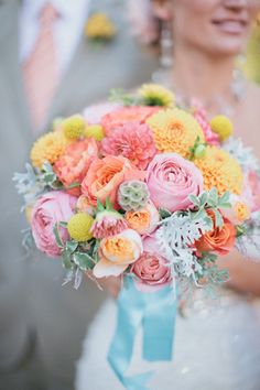 a bride holding a bouquet of colorful flowers