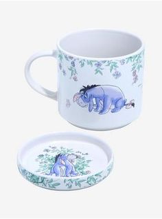 a white coffee cup with an image of a rhino on the side and a small plate underneath it