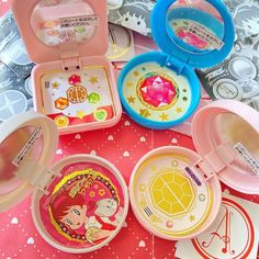 several children's plates and bowls on a pink tablecloth with various cartoon designs