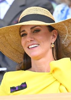 a woman wearing a yellow dress and large hat