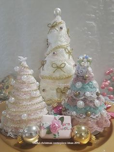 three small christmas trees sitting on top of a table next to other ornaments and decorations