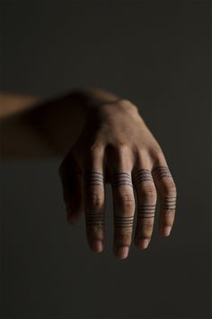 a hand with two small tattoos on it's fingers and the words cremebydesign written in cursive ink