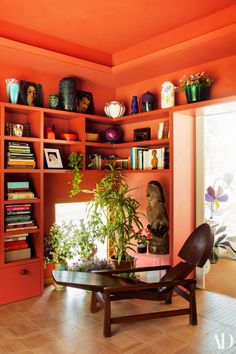 a living room filled with lots of books and plants