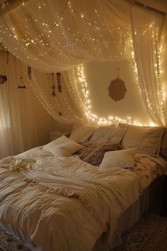 an unmade bed with lights on the headboard and canopy over it in a bedroom