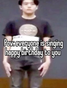 a man standing in front of a wall with the words pov everyone is singing happy birthday to you