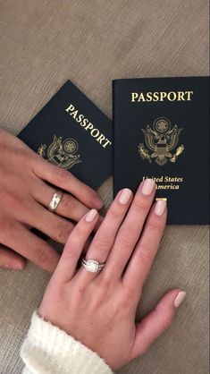 two people with their hands on each other's fingers, one holding a passport