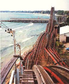 an overhead view of a train track next to the ocean