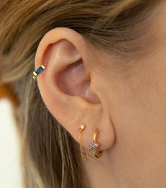 a close up of a person's ear with two piercings on it,