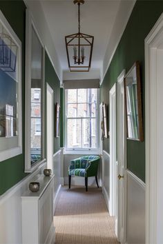 a hallway with green walls and white trim