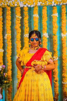 a woman dressed in yellow and red poses for the camera with her hands on her hips