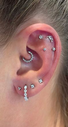 a woman's ear with multiple piercings on it