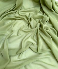 a close up view of a green fabric with very thin folds on the top and bottom