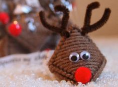 a knitted reindeer head sitting on top of a white carpet