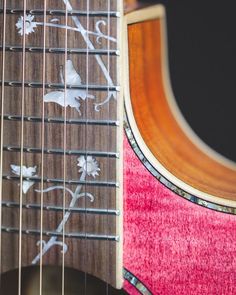 a close up of the frets on an acoustic guitar with flowers and leaves painted on it