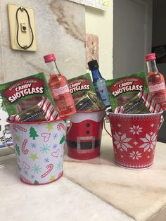 three buckets filled with christmas drinks and candy canes on top of a counter